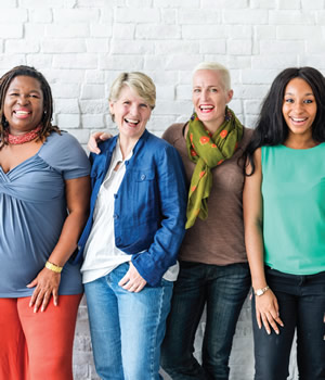 four smiling women standing together