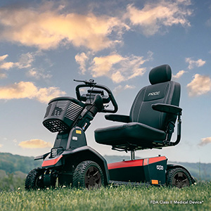 PX4 scooter with red accents in a grassy field under a blue sky with white clouds.